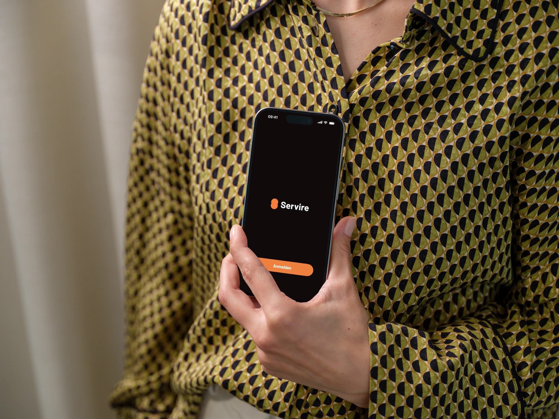 Servire Kassen-App auf einem iPhone in der Hand einer Mitarbeiterin