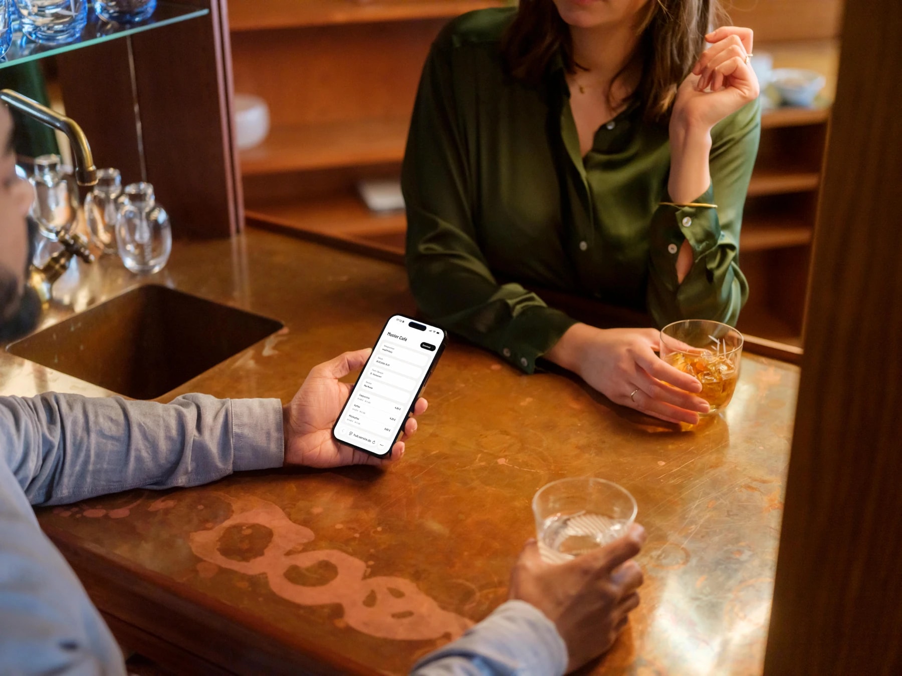 Gastronom prüft die Servire Kassen-App auf dem iPhone im Gastraum