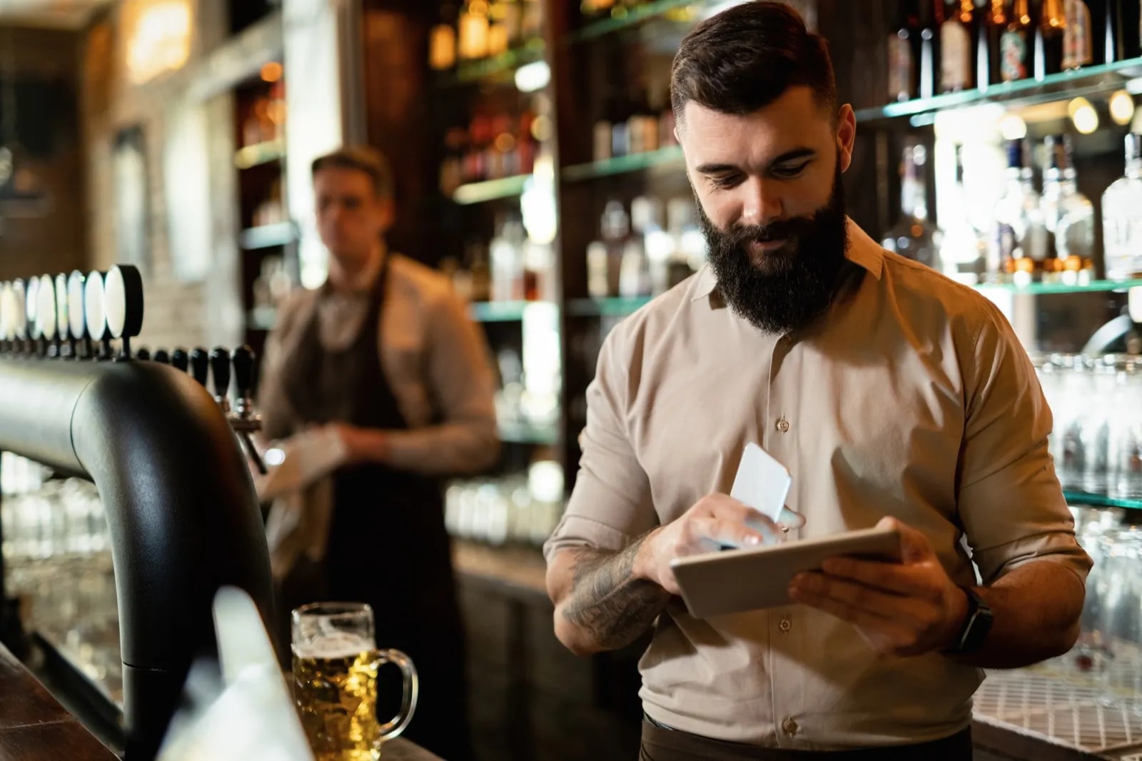 Bartender using tablet at the bar